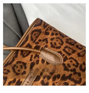 Detail show of leopard print plush tote bag with brown leather trim and high-quality stitching