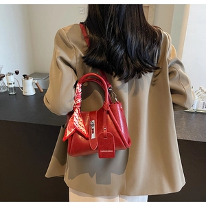 Sac seau en cuir rouge avec foulard à damier sur l'anse et étiquette en cuir élégante