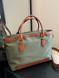 Dark green canvas and brown leather tote bag with top handles and adjustable strap