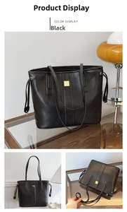 Detail of black large capacity tote bag featuring gold hardware and smooth faux leather