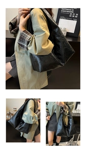 Dettaglio della borsa tote nera minimalista in pelle lucida e stile hobo per uso quotidiano