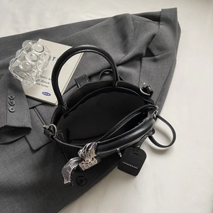 Sac seau minimaliste en cuir noir avec foulard en soie et poche intérieure zippée