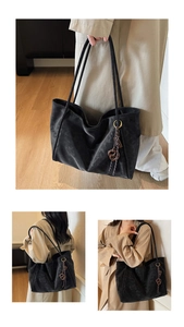 Three-way view of a large black suede tote bag with fringe charm and long shoulder straps