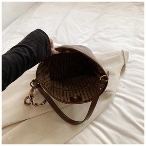 Interior view of brown faux leather tote bag with striped lining and leopard print scarf
