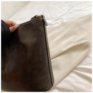 Detail of vintage dark brown bucket bag showing matte leather texture and gold metal ring
