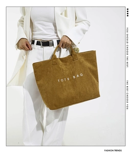 Detailed texture of retro brown corduroy tote bag with white TOTE BAG lettering