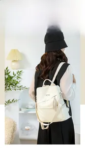 Cream soft leather backpack for women featuring a side pocket and decorative tassel detail