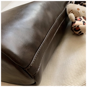 Close-up of vintage brown leather bag showing premium double-stitched sewing details