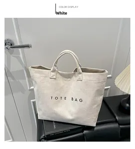 Detail of minimalist cream faux suede tote bag with black TOTE BAG lettering text