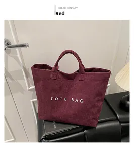 Close-up of deep red tote bag made of matte suede with white printed TOTE BAG text