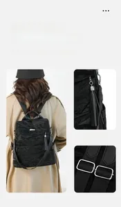 Detail of black backpack showing wrinkled texture, tassel ornament, and adjustable strap