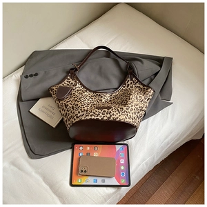 Detailed top view of large leopard print canvas hobo bag with brown leather trim details