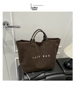Detailed close-up of dark coffee suede tote bag with white TOTE BAG lettering print