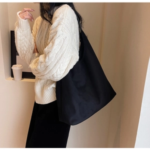 Minimalist black matte tote bag shown in a stylish urban casual lifestyle setting