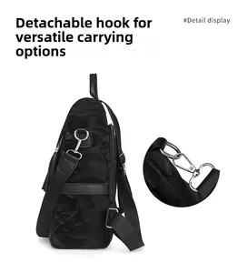 Detail view of black textured backpack with removable silver hooks and nylon straps