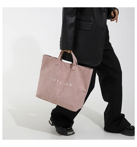Detail of vintage pink corduroy tote bag featuring striped texture and tote bag text