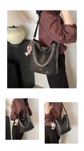 Close-up of vintage leather hobo bag with gold logo and leopard print bear charm