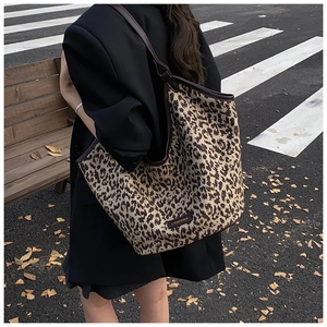 Detailed look at the leopard print canvas tote bag on model in a stylish street setting