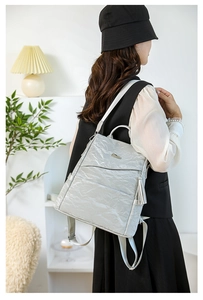 Detail of silver textured leather backpack with side fringe charm and front pocket