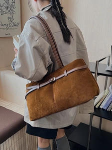 Grand sac cabas rétro en daim caramel avec boucle métallique porté par un mannequin