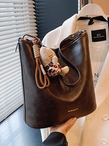 Retro dark brown textured faux leather tote bag with shoulder strap and plush charm