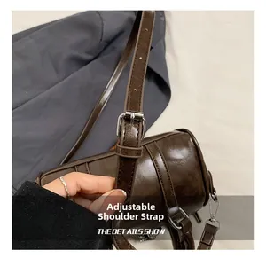 Detail view of the brown leather Boston bag featuring an adjustable shoulder strap with silver buckle