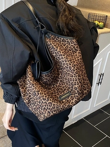 Large leopard print canvas tote bag with black leather straps shown on shoulder