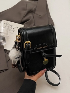 Glossy black leather crossbody bag for women with plush charm and fashion branding