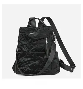Detail view of the black pleated leather backpack with tassel charm and silver hardware