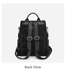 Back view of black nylon backpack showing adjustable straps and leather top handle