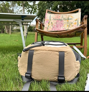 Detailed outdoor view of khaki nylon backpack featuring durable crinkled fabric texture