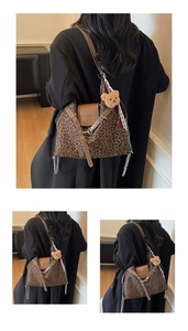 Detailed view of leopard print tote bag featuring metal chain and plush bear charm decoration