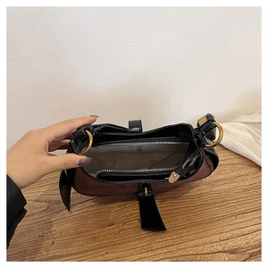 Detail view showing the spacious interior compartment and zip pocket of this crescent bag