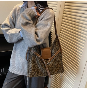 Detail of leopard print hobo bag showing brown leather trim and silver chain strap
