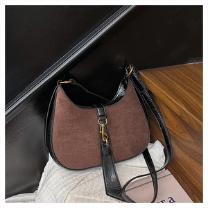 Detail of vintage crescent bag with brown suede and black patent leather stitching