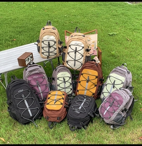 Outdoor backpacks in various colors displayed on grass for a camping and hiking setup