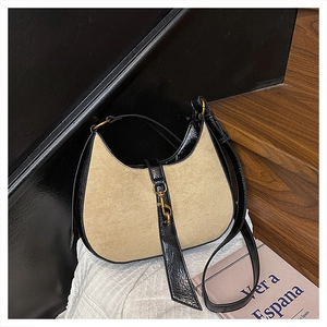 Close-up of contrast stitching crescent bag with suede and gold lobster clasp detail