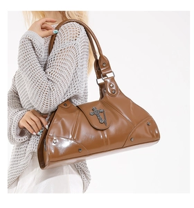 Side view of a brown glossy PU leather satchel featuring vintage cross charms and studs