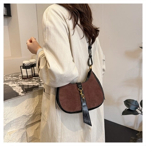 Detail of vintage brown suede crescent bag with leather trim and gold metal piston clasp