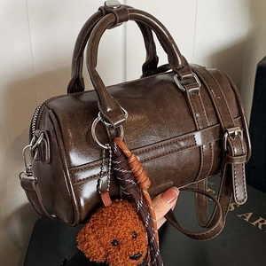 Deep brown glossy Boston bag with silver hardware and a cute teddy dog charm