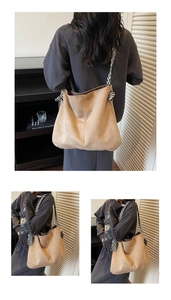 Detail of khaki hobo bag featuring a black and white striped wide knot shoulder strap