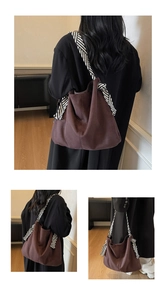 Detail of dark brown tote bag with stylish black and white striped shoulder strap