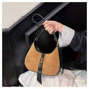 Detail of vintage hobo bag featuring brown suede and golden piston clasp buckle