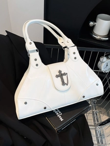 White faux leather trapezoid bag with gothic metal cross, chains, and studded edges