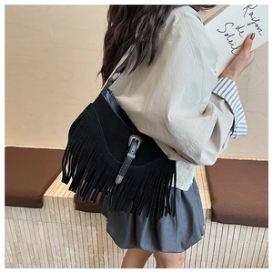 Détail du sac noir vintage à franges avec boucle argentée et texture en daim