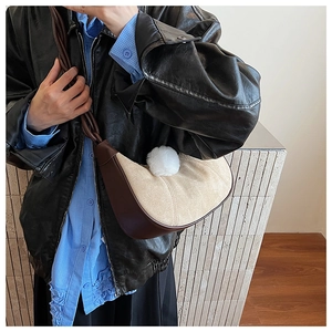 Close-up of crescent shoulder bag in khaki suede and brown leather with plush ball