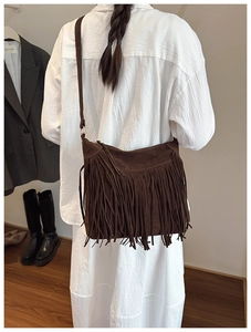 Détail d'un sac bandoulière vintage en daim marron avec de longues franges