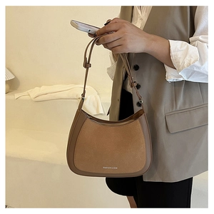 Détail d'un sac cabas demi-lune marron bicolore en cuir avec bandoulière réglable