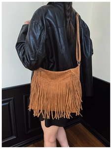 Détail d'un sac bandoulière en daim marron à longues franges porté par un mannequin