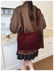 Vue détaillée du sac bandoulière à franges en daim bordeaux porté par un mannequin